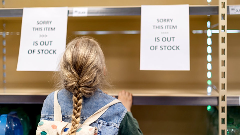 young girls hopper looking at empty shelf in retail store with sign reading sorry this item is out of stock