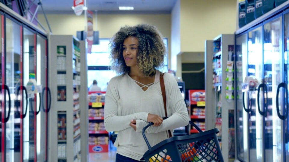 female shopper in retail grocery refrigerated aisle